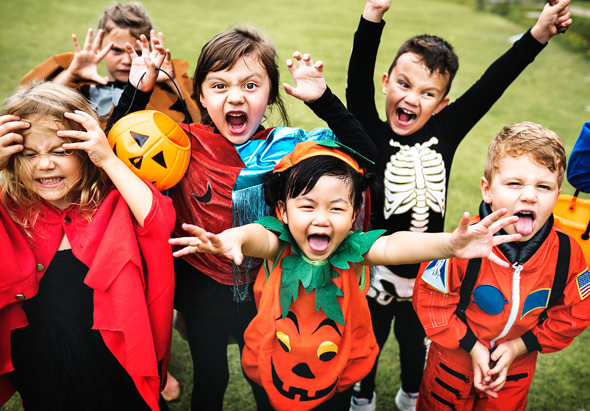 A group of excited kids in Halloween costumes