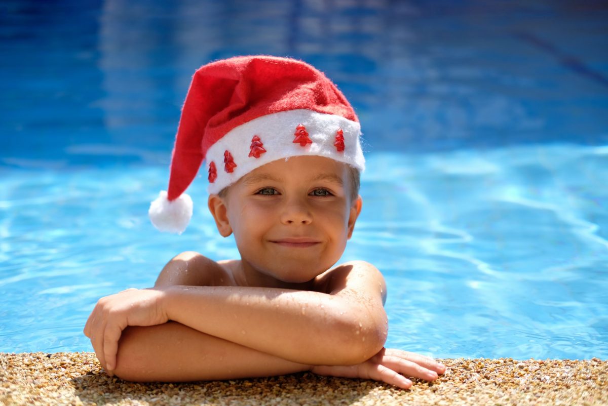 Boy in swimming pool wearing Santa hat